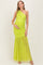 woman wearing a bright neon green one-shoulder maternity gown with ruched detailing and a flowing skirt, showing her baby bump
