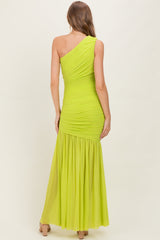 woman wearing a bright neon green one-shoulder maternity dress with ruched detailing and a flowing skirt