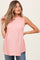 woman wearing a light pink maternity top with a tied neckline and flowy silhouette, displaying her baby bump