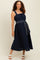woman wearing a navy blue maternity dress with a square neckline and waist tie detail