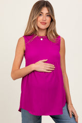 woman wearing a bright pink sleeveless maternity top and holding her baby bump