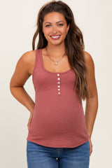woman wearing a rust-colored maternity tank top with button details and a visible baby bump