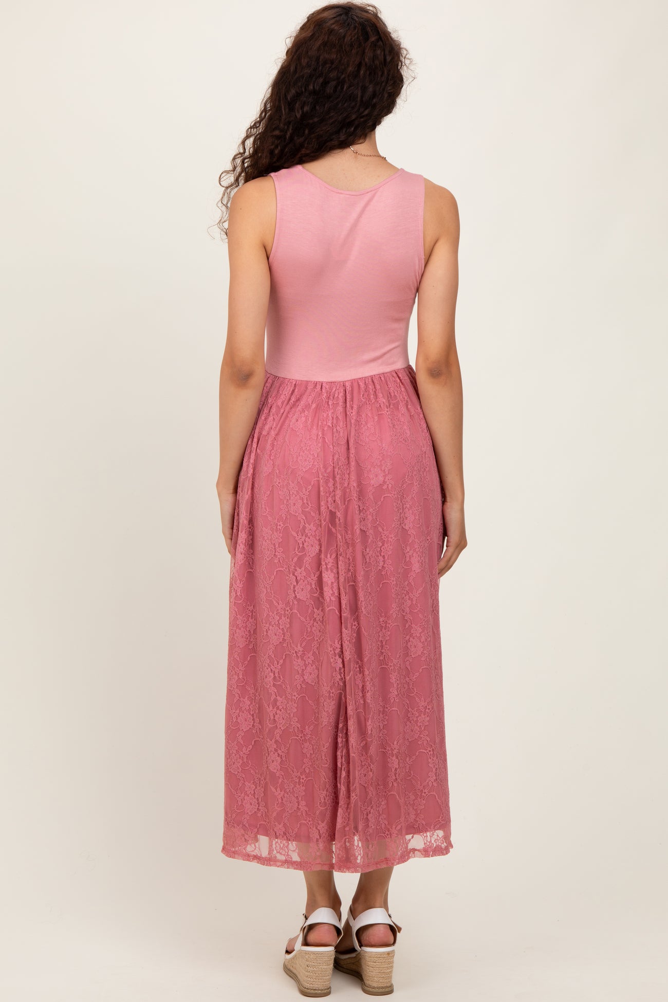 woman wearing a pink maxi dress with a lace skirt and a fitted top, showing the back view
