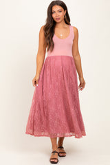 woman wearing a pink maternity dress with a fitted bodice and lace skirt, showing a baby bump