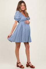 woman wearing a blue and white striped maternity dress with puff sleeves and a baby bump visible