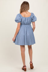 woman wearing a blue striped maternity dress with puff sleeves and a cinched waist, showing the back view
