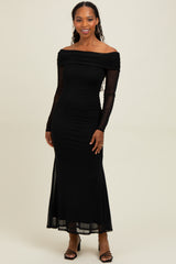 woman wearing a black off-the-shoulder long sleeve dress with a fitted silhouette and sheer sleeves