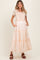 woman wearing a beige and peach tiered maxi maternity dress with embroidered details and pockets