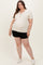 woman wearing a cream ribbed maternity top with a v-neck and buttons, paired with black shorts and showing her baby bump