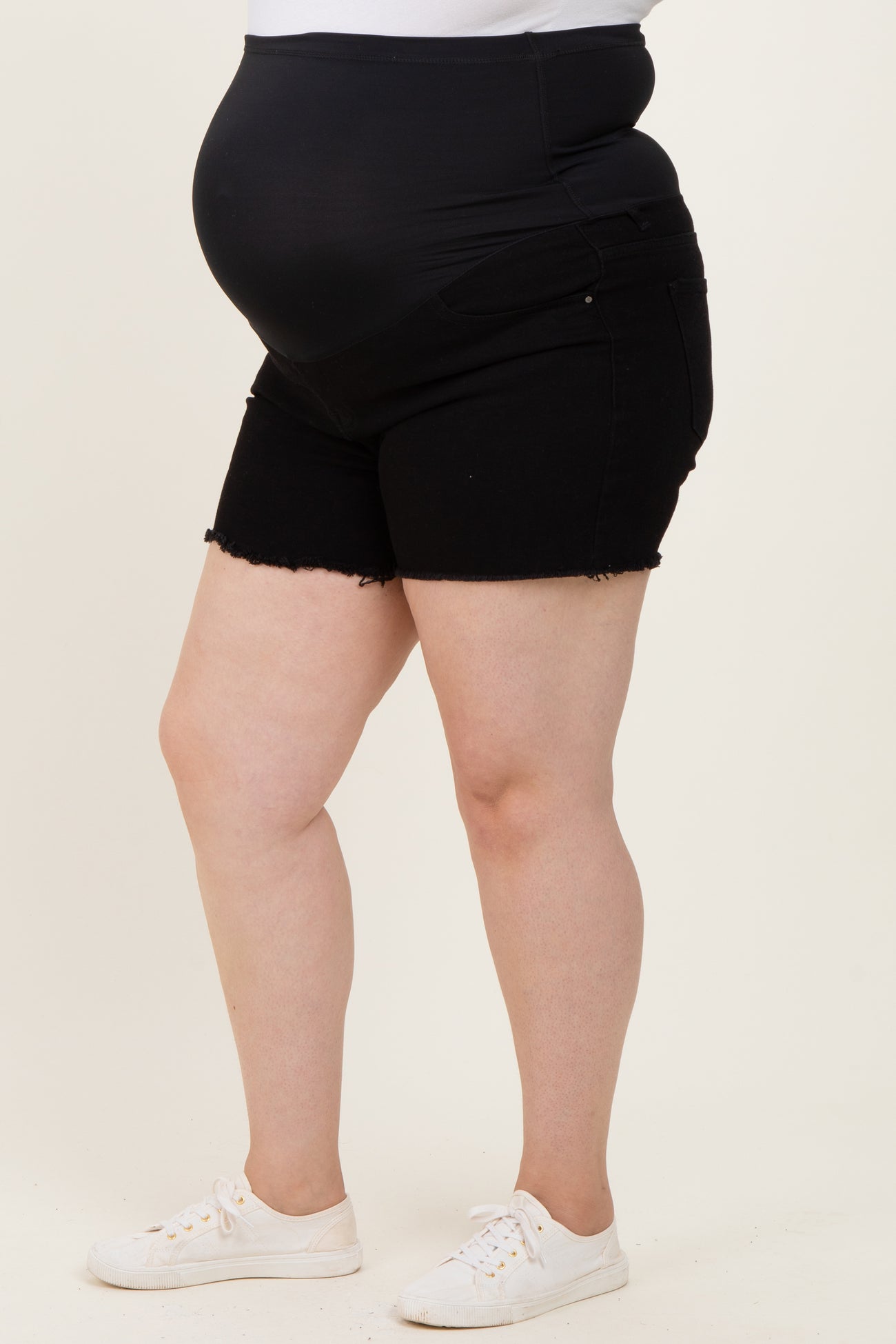 woman wearing black maternity plus shorts with a stretchy waistband and a visible baby bump