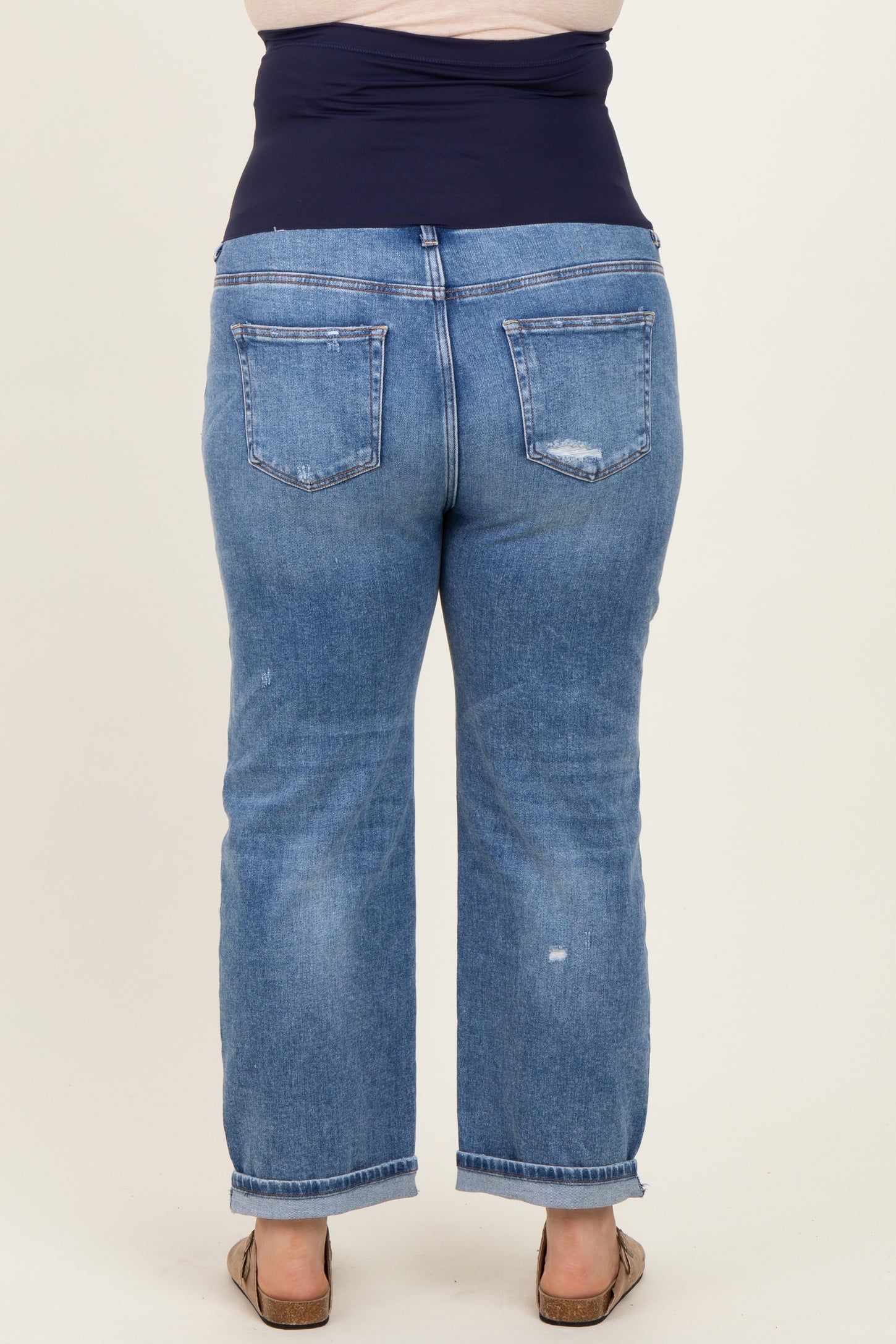 woman wearing a blue maternity plus size jeans with a dark waistband, showing the back view