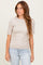 woman wearing a light beige ribbed short sleeve top with a fitted silhouette and a round neckline