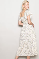 woman wearing a cream floral midi dress with puff sleeves and a smocked bodice, shown from the back