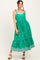 woman wearing a green sleeveless maxi dress with tie straps and floral embroidery along the hemline