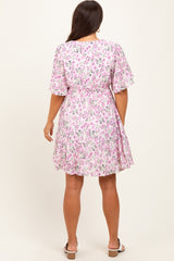 woman wearing a floral pink maternity dress with short sleeves and a cinched waist, showing her baby bump from the back