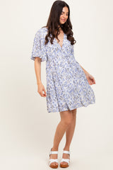 woman wearing a light blue floral short dress with a deep v-neck and flutter sleeves