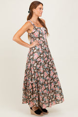 woman wearing a brown floral maxi dress with adjustable straps and a tiered skirt