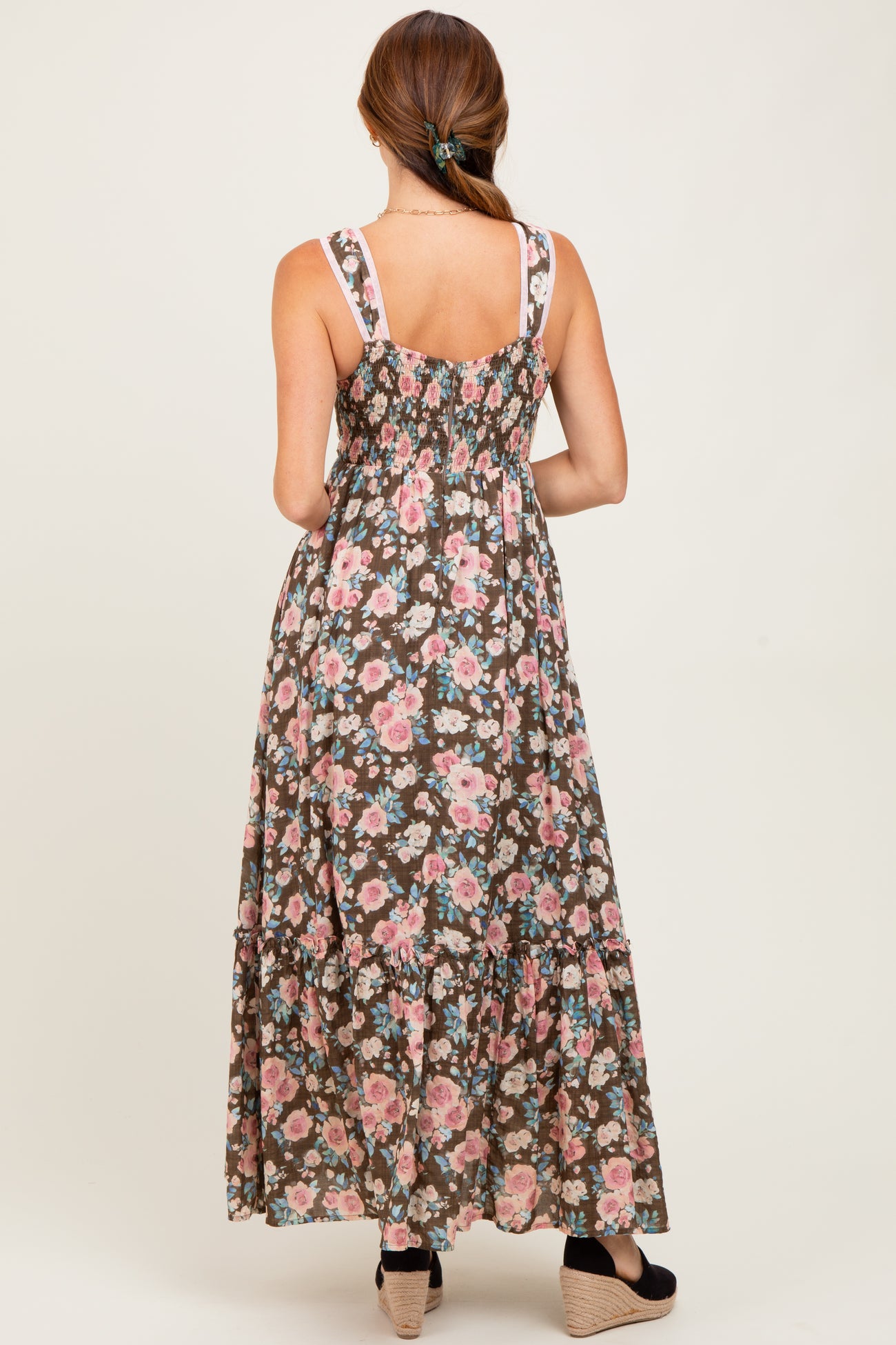 woman wearing a floral patterned brown maxi dress with a smocked back and tiered ruffle hemline