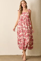 woman wearing a pink floral maxi dress with tie straps and a tiered skirt