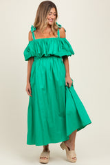 woman wearing a bright green maternity maxi dress with off-the-shoulder ruffled sleeves and tied straps