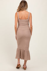woman wearing a light brown maternity knit dress with a ruffled hem and adjustable straps, showing her back
