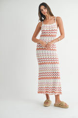 woman wearing a white and coral zigzag patterned maxi dress with spaghetti straps and tan slide sandals
