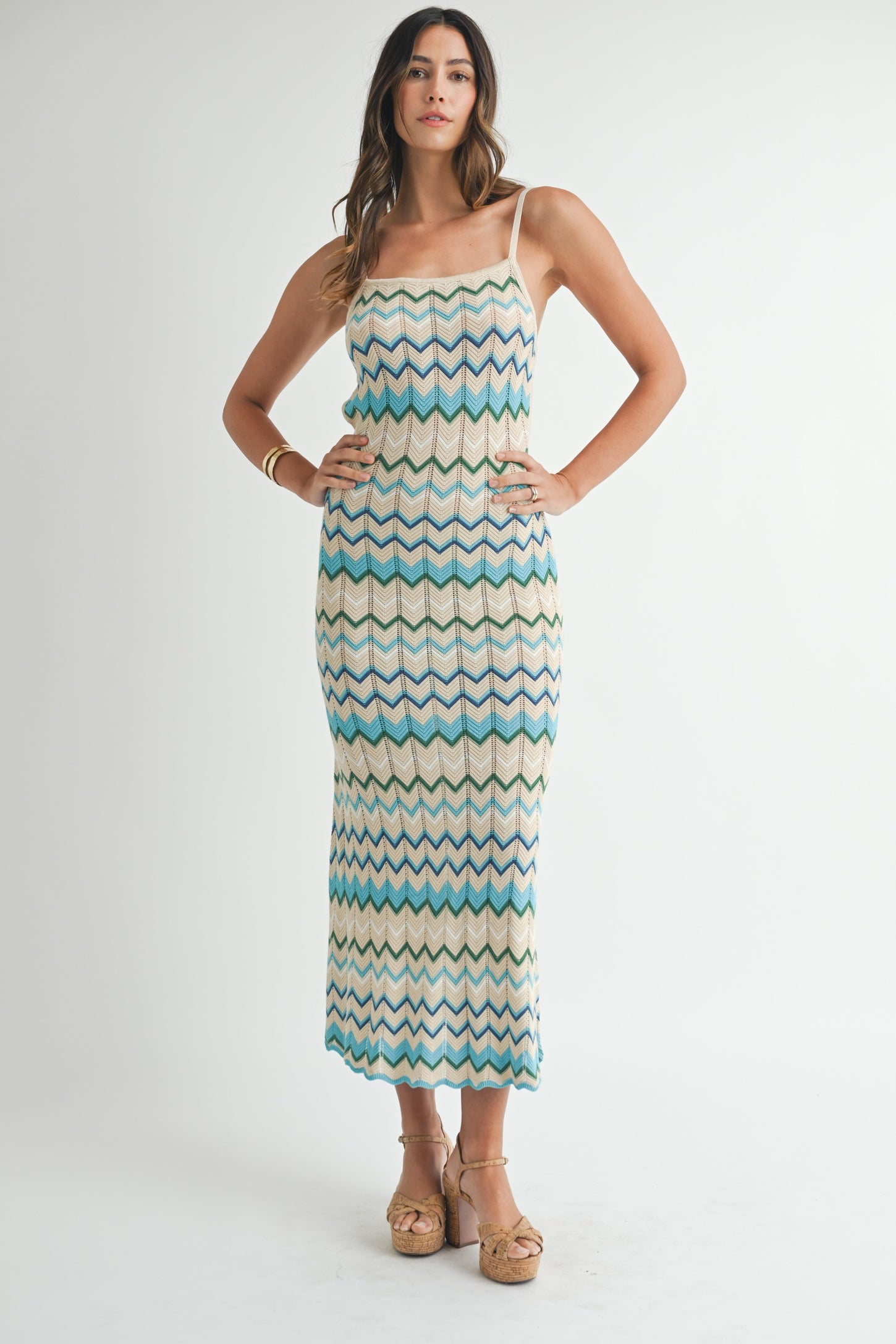 woman wearing a cream and blue zigzag patterned maxi dress with adjustable straps and chunky platform sandals