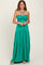 woman wearing a green halter neck maxi dress with a smocked bodice and tiered skirt