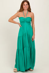 woman wearing a green halter maxi dress with smocked bodice and tiered skirt