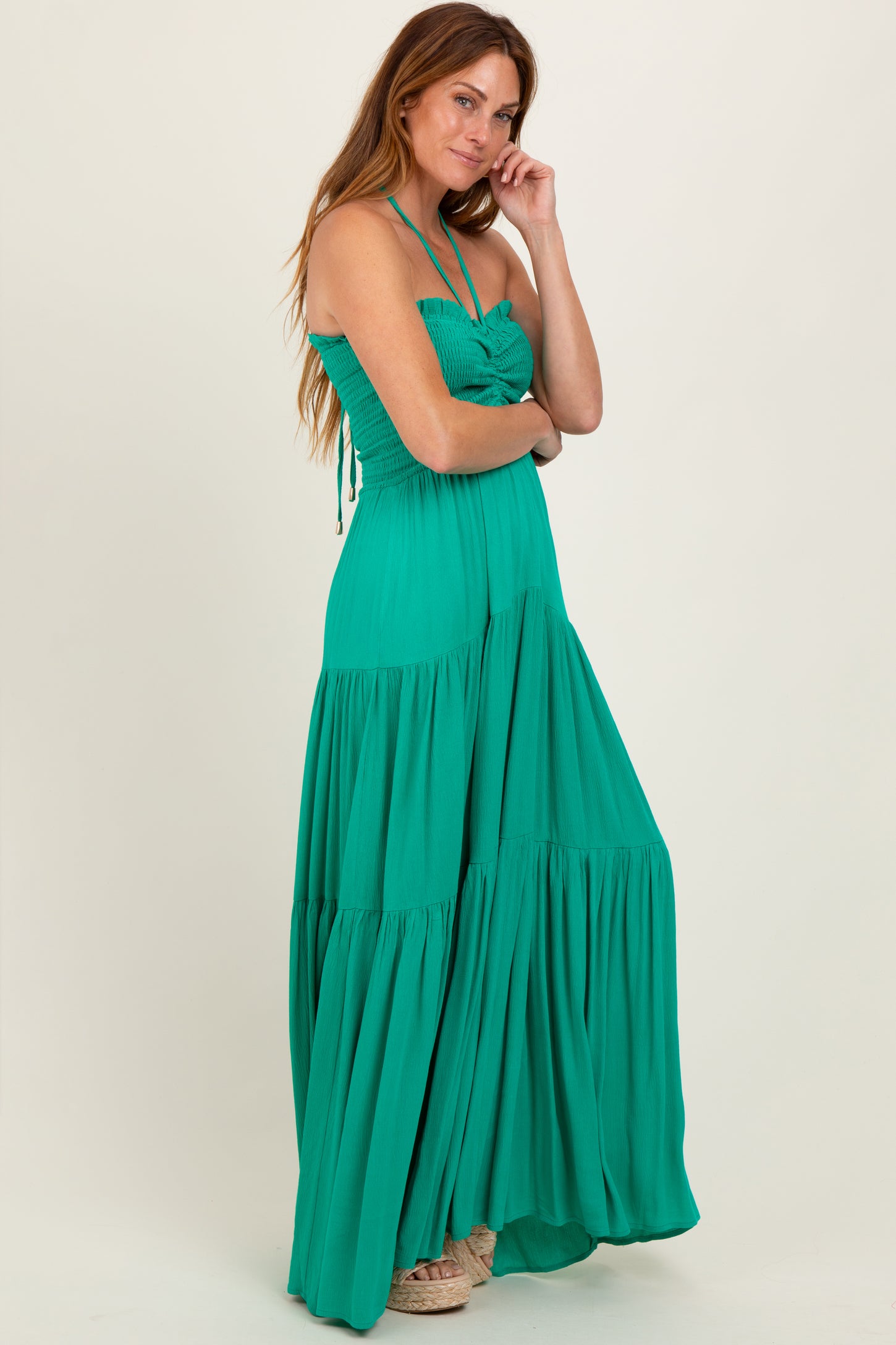 woman wearing a green strapless maxi dress with a smocked bodice and tiered skirt