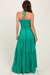 woman wearing a strapless green maxi dress with a smocked bodice and tiered skirt, seen from the back