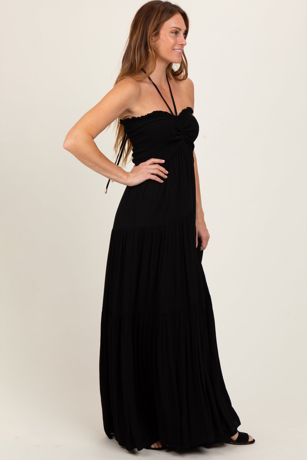 woman wearing a black strapless maxi dress with a fitted bodice and flowing skirt