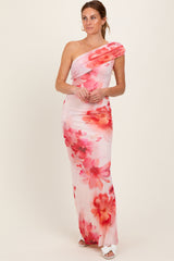 woman wearing a one-shoulder floral maxi dress in pink and red hues
