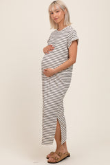 woman wearing a striped maternity maxi dress and holding her baby bump