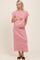 woman wearing a pink and white striped maternity maxi dress and holding her baby bump