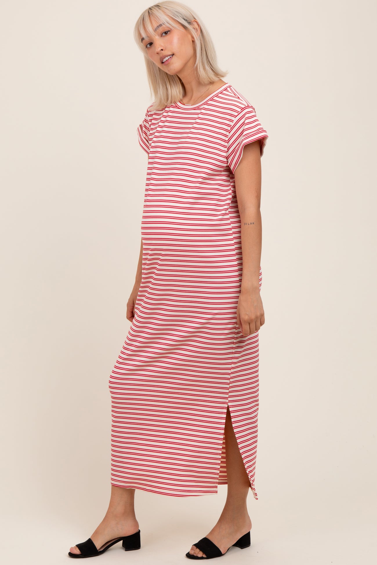 woman wearing a striped maternity maxi dress with short sleeves and a side slit, showcasing her baby bump