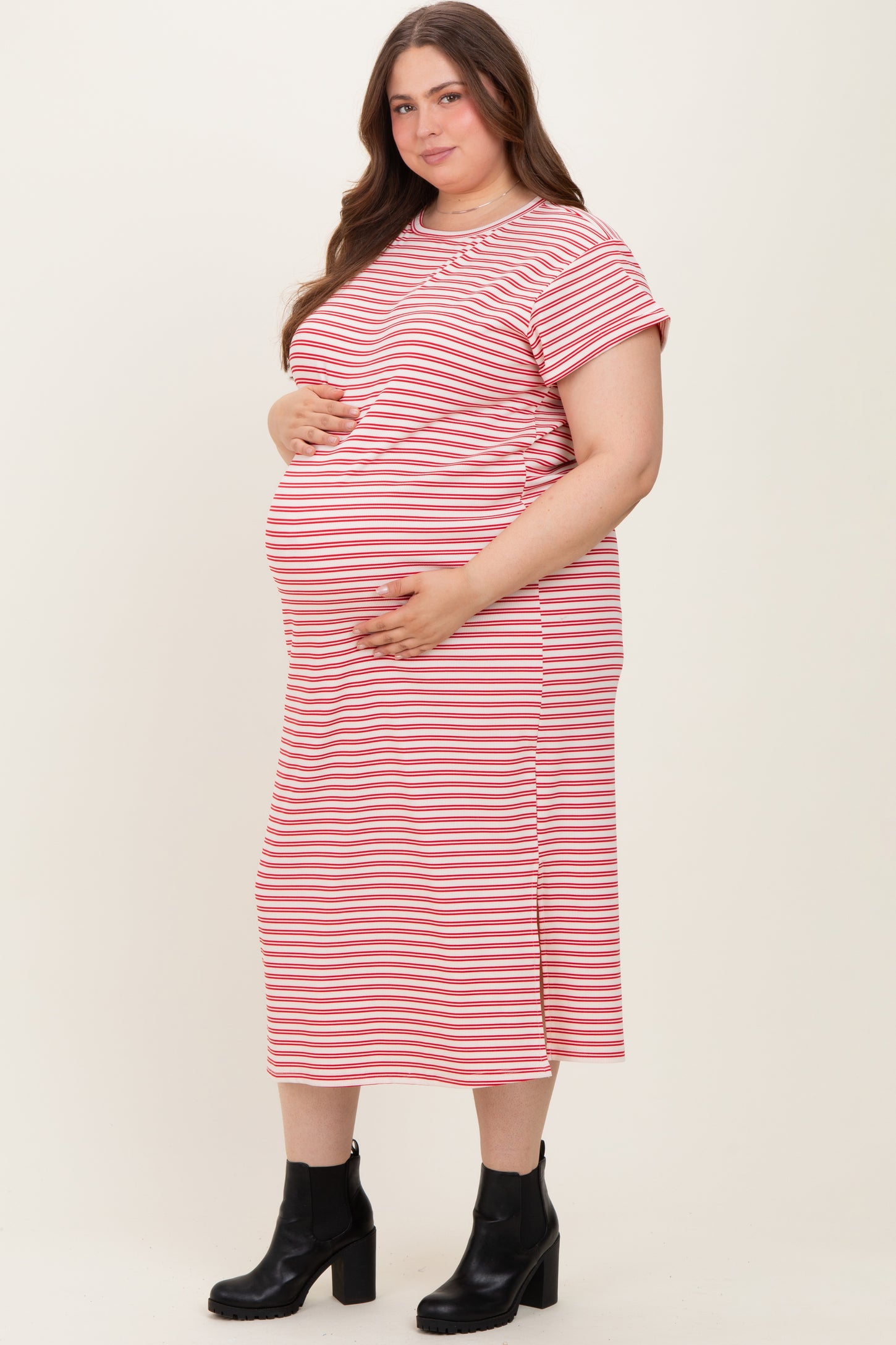 woman wearing a pink and white striped maternity dress, holding her baby bump