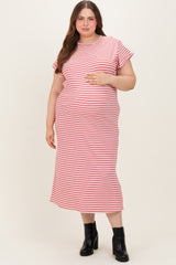 woman wearing a pink and white striped maternity plus maxi dress and holding her baby bump
