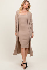 woman wearing a beige ribbed midi dress with a matching long cardigan and black heeled sandals