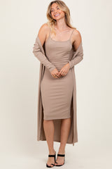 woman wearing a ribbed beige midi dress with a matching long cardigan and black strappy heels