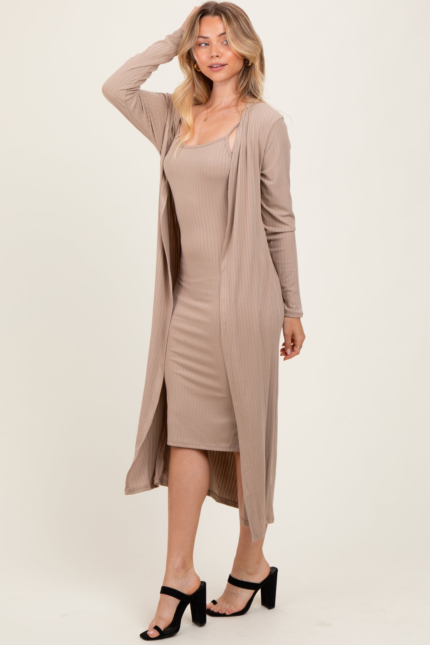 woman wearing a beige ribbed midi dress with a matching long cardigan and black heeled sandals