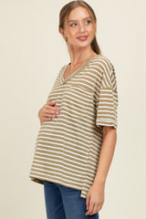woman wearing a brown and beige striped maternity top and holding her baby bump