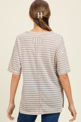 woman wearing a light gray and white striped maternity top with a back button detail and loose fit