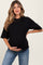 woman wearing a black maternity t-shirt and holding her baby bump, paired with blue jeans