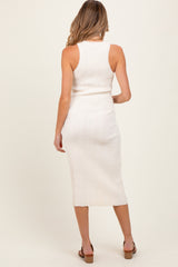 woman wearing a cream ribbed maternity dress with a midi length and fitted style, showing her back
