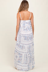 woman wearing a floral print maternity maxi dress with a tiered design and adjustable spaghetti straps seen from the back