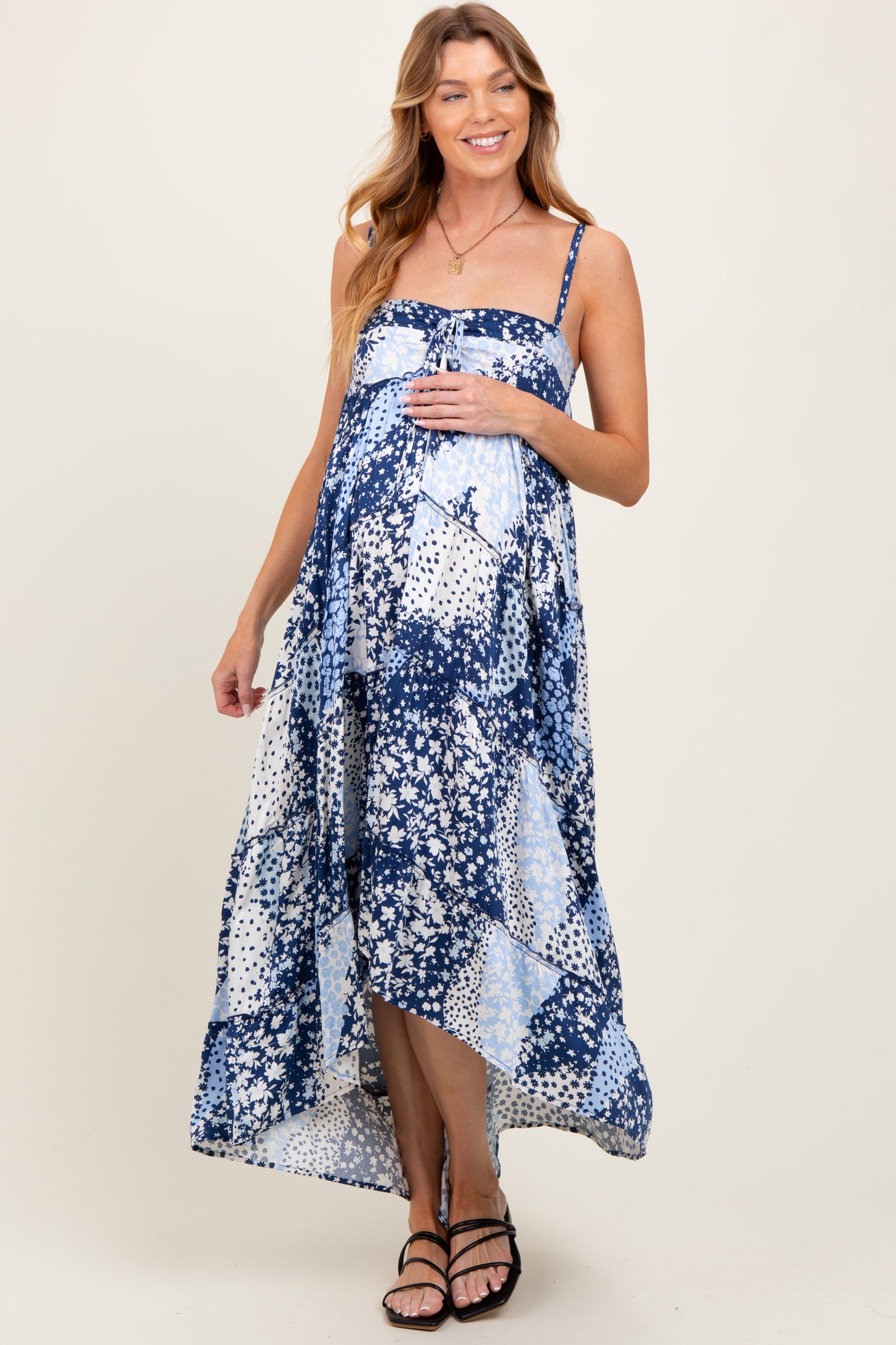 woman wearing a navy blue and white tie-dye maternity maxi dress with a flowing silhouette and an exposed baby bump