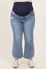 woman wearing light blue distressed maternity jeans with a navy high waistband and frayed hem, no visible baby bump