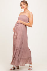 woman wearing a light mauve strapless maternity maxi dress, showing her baby bump with a tiered skirt and a drawstring detail