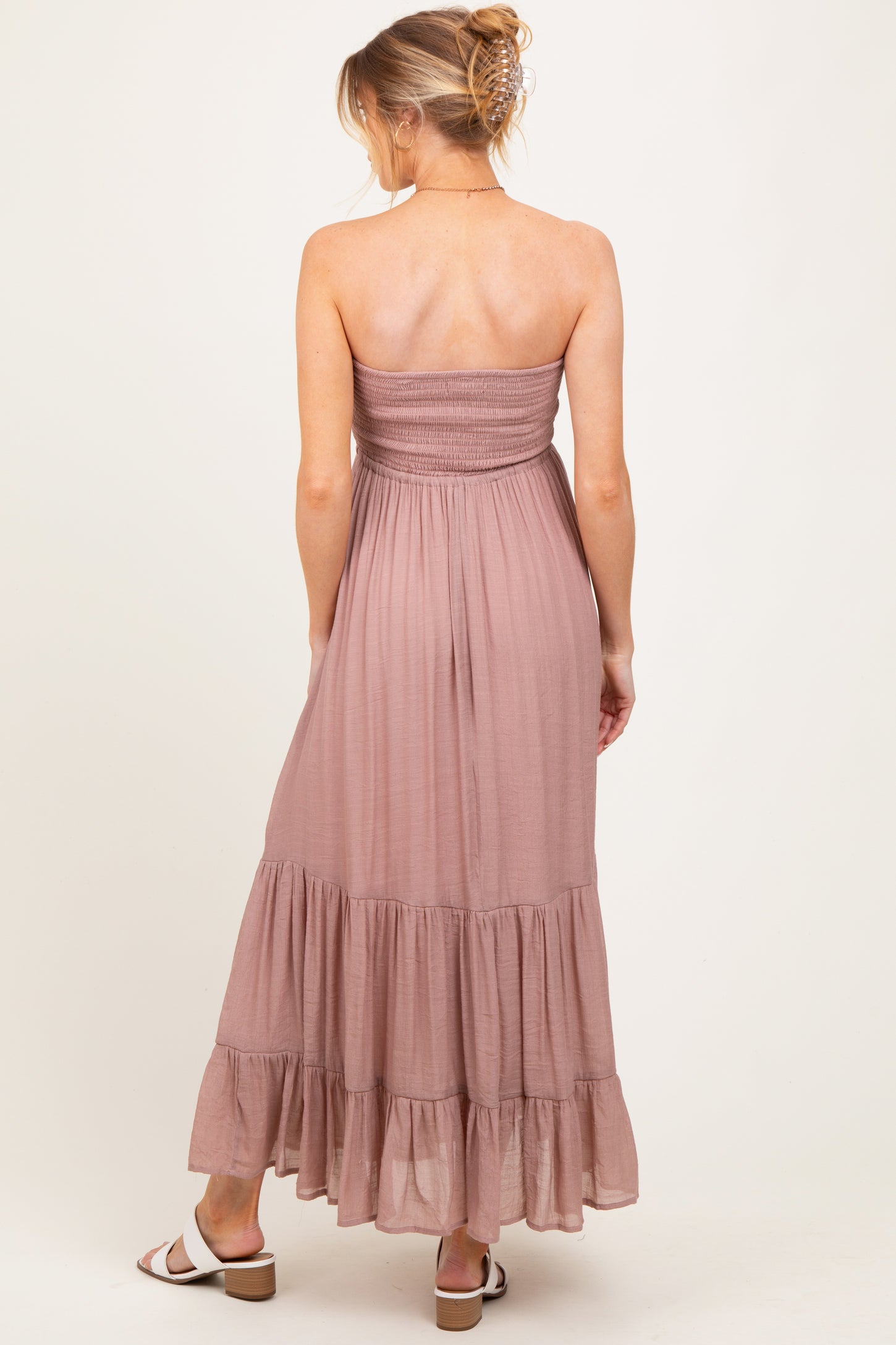 woman wearing a dusty rose strapless maternity maxi dress with a smocked bodice and tiered hem, seen from the back